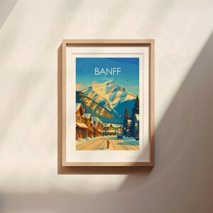 Puede incluir: Una impresi&oacute;n art&iacute;stica enmarcada con una ilustraci&oacute;n estilizada de Banff, Canad&aacute;. La obra representa una cordillera nevada, una calle con edificios y el texto "BANFF Canada" en la parte superior.