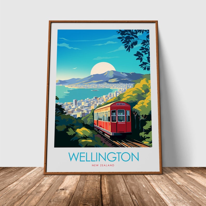 Może przedstawiać: Oprawiony wydruk artystyczny z zabytkowym plakatem podr&oacute;żniczym dla Wellington w Nowej Zelandii. Plakat przedstawia czerwoną kolejkę linową wspinającą się po zboczu wzg&oacute;rza, z widokiem na miasto i port. Niebo jest niebieskie z dużym słońcem, a u dołu znajduje się napis "WELLINGTON NEW ZEALAND".