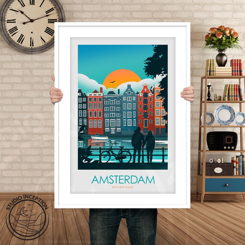 May include: A colorful illustration of Amsterdam, Netherlands, with a couple standing on a bridge overlooking a canal with a bicycle. The illustration features a sunset with a bright orange sun and a blue sky with white clouds. The buildings are red, orange, yellow, and blue. The text "AMSTERDAM" and "NETHERLANDS" is printed below the illustration.