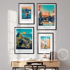 May include: Four framed travel posters with colorful illustrations of Budapest, Prague, Machu Picchu, and Lisbon. The posters are hanging on a white wall above a wooden desk with a book and a vase of flowers.