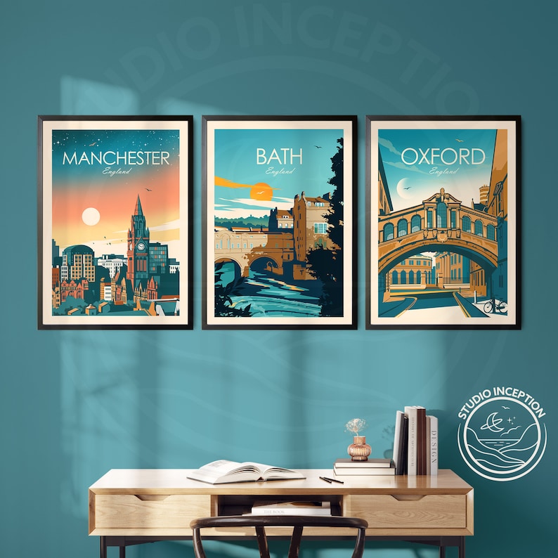 May include: Three framed vintage travel posters with illustrations of cityscapes. The posters are in black frames and feature the cities of Manchester, Bath, and Oxford, England. Each poster has a colorful illustration of a famous landmark in the city.
