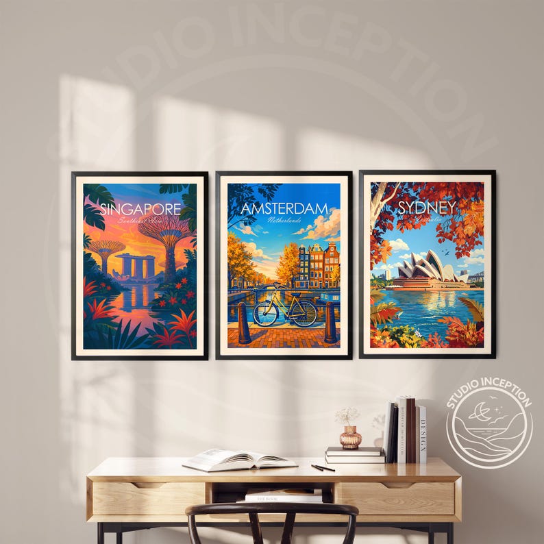 May include: Three framed travel art prints featuring Singapore, Amsterdam, and Sydney. The Singapore print shows a sunset over the city's gardens. The Amsterdam print depicts a bicycle on a bridge. The Sydney print shows the Opera House.