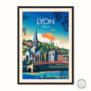 May include: Framed art print of Lyon, France, with a stylized illustration. It shows a church with a spire, a bridge, and buildings under a sunset. The word "LYON" is at the top, with "France" below.