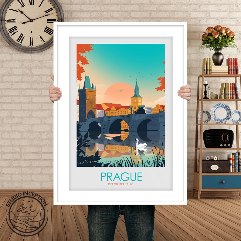 May include: A colorful illustration of Charles Bridge in Prague, Czech Republic. The bridge is depicted with a reflection in the water below. A white swan is swimming in the water. The text "PRAGUE" and "CZECH REPUBLIC" is printed below the image.