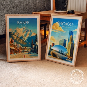 Puede incluir: Dos p&oacute;steres de viaje en marcos de madera clara. El p&oacute;ster izquierdo muestra una calle nevada de Banff, Canad&aacute;, con monta&ntilde;as. El derecho muestra el horizonte de Chicago, Illinois, con la escultura Cloud Gate bajo un cielo azul.