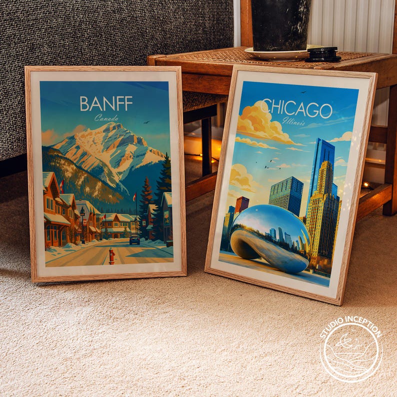 Puede incluir: Dos p&oacute;steres de viaje en marcos de madera clara. El p&oacute;ster izquierdo muestra una calle nevada de Banff, Canad&aacute;, con monta&ntilde;as. El derecho muestra el horizonte de Chicago, Illinois, con la escultura Cloud Gate bajo un cielo azul.