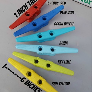 May include: Six colorful boat cleats in cherry red, deep blue, ocean breeze, aqua, key lime, and sun yellow. Each cleat is 6 inches long and 1 inch tall. The image includes the text "Pick a Color".