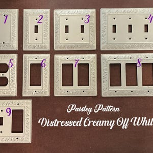 May include: A collection of nine distressed creamy off-white light switch plates and outlet covers featuring a raised paisley pattern border. Each plate is numbered one through nine, showcasing various configurations for switches and outlets.