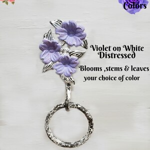 May include: A distressed white metal towel ring featuring three lavender flower blooms and leaves. The text reads "Violet on White Distressed" and "Blooms, stems & leaves your choice of colour".