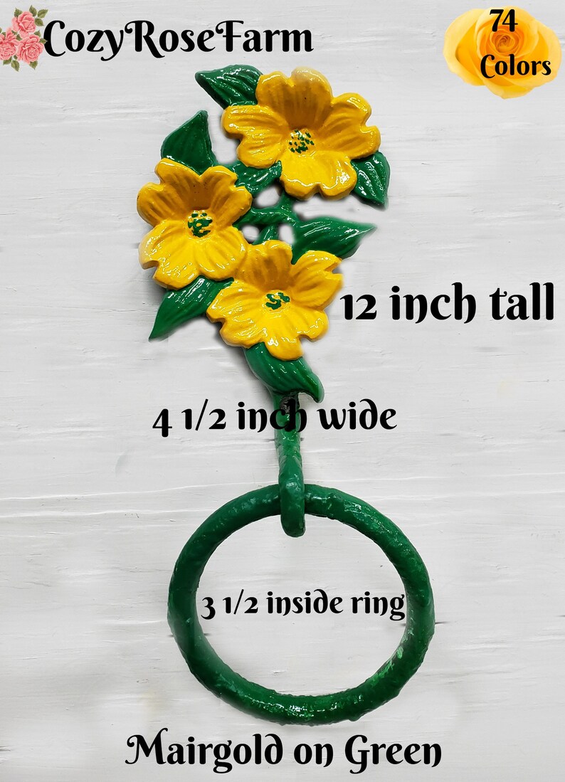 May include: A decorative wall-mounted towel ring with three yellow marigold flowers and green leaves. The towel ring is 30.5 cm tall, 11.4 cm wide, and has an 8.9 cm inside ring. The text "Cozy Rose Farm" and "74 Colors" are visible.