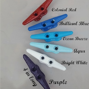 May include: Five painted cleats in a variety of colors: Colonial Red, Brilliant Blue, Ocean Breeze, Aqua, Bright White, and Purple. Each cleat is 4 inches long. The cleats have two holes for securing ropes.