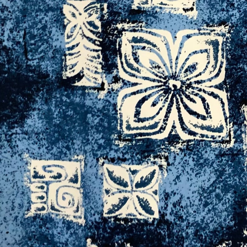 May include: A blue and white fabric with a repeating pattern of stylized flowers and geometric shapes. The fabric has a textured, slightly distressed look.