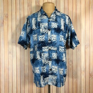 May include: A blue and white patterned short-sleeved button-up shirt with a traditional Hawaiian design.