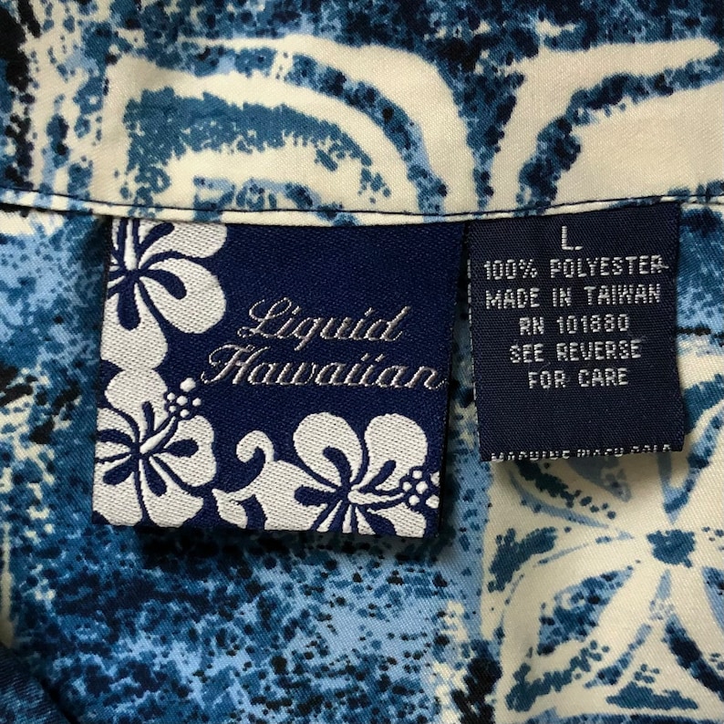May include: A blue and white patterned shirt with a tag that reads "Liquid Hawaiian" and "100% Polyester Made in Taiwan RN 101880 See Reverse for Care".