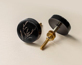 Minimalistic black furniture knob with summer grass