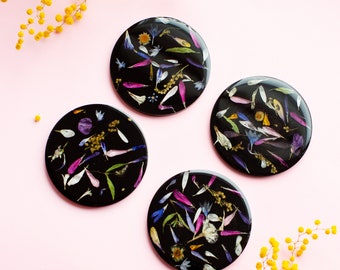 Black coasters with colorful real flower petals