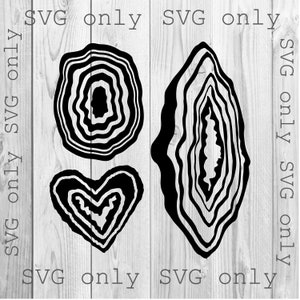 May include: Three black and white agate designs in the shapes of a circle, a heart, and a teardrop. The designs are on a woodgrain background.
