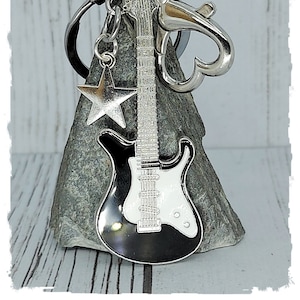Gitaar zwart en wit met ster of wit en zwart en liefdeshart sleutelhanger op een kaart in een verzegelde cellofaan hoes geweldig cadeau