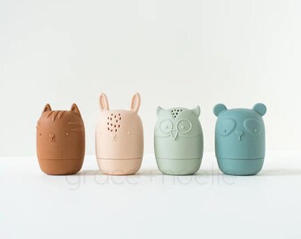 May include: Four small, colorful silicone bath toys shaped like animals: a cat, a rabbit, an owl, and a bear. The toys have holes for water to flow through.