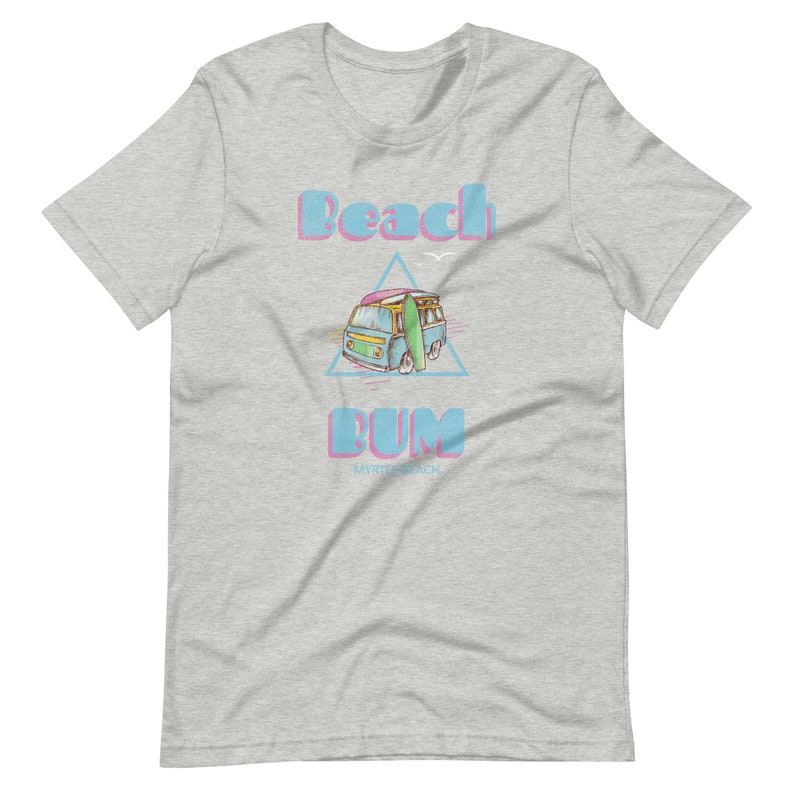 May include: A light gray t-shirt with a blue and pink graphic of a vintage van with a surfboard on top. The text "Beach Bum" is above the van and "Myrtle Beach" is below the van.