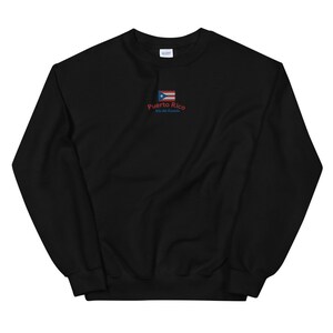 May include: Black sweatshirt with a red and blue Puerto Rican flag and the text "Puerto Rico, Isla del Encanto" embroidered on the front.