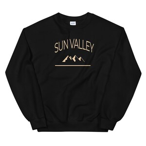 May include: Black sweatshirt with a beige graphic of mountains and the text "SUN VALLEY" in a curved font.
