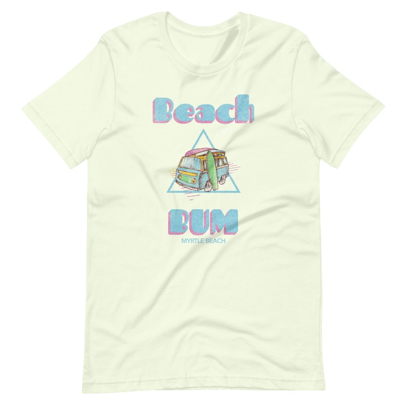 May include: A light green t-shirt with a retro-style graphic of a blue van with a surfboard on top. The text "Beach Bum" is in pink and blue letters with a pink and blue triangle behind the van. The text "Myrtle Beach" is in smaller black letters below the graphic.