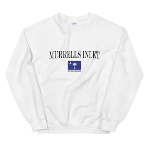 May include: White sweatshirt with black text that reads "Murrells Inlet" and a small blue South Carolina flag.