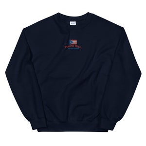 May include: Navy blue sweatshirt with a small embroidered Puerto Rican flag and the text "Puerto Rico, Isla del Encanto".