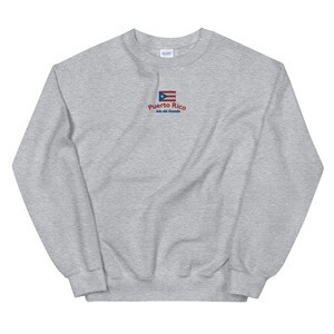 May include: A gray sweatshirt with a small embroidered image of the Puerto Rican flag and the text "Puerto Rico, Isla del Encanto".