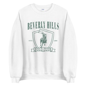 May include: White sweatshirt with a green graphic of a polo player on a horse, with the text "Beverly Hills Polo Club" and "Est. 1990".