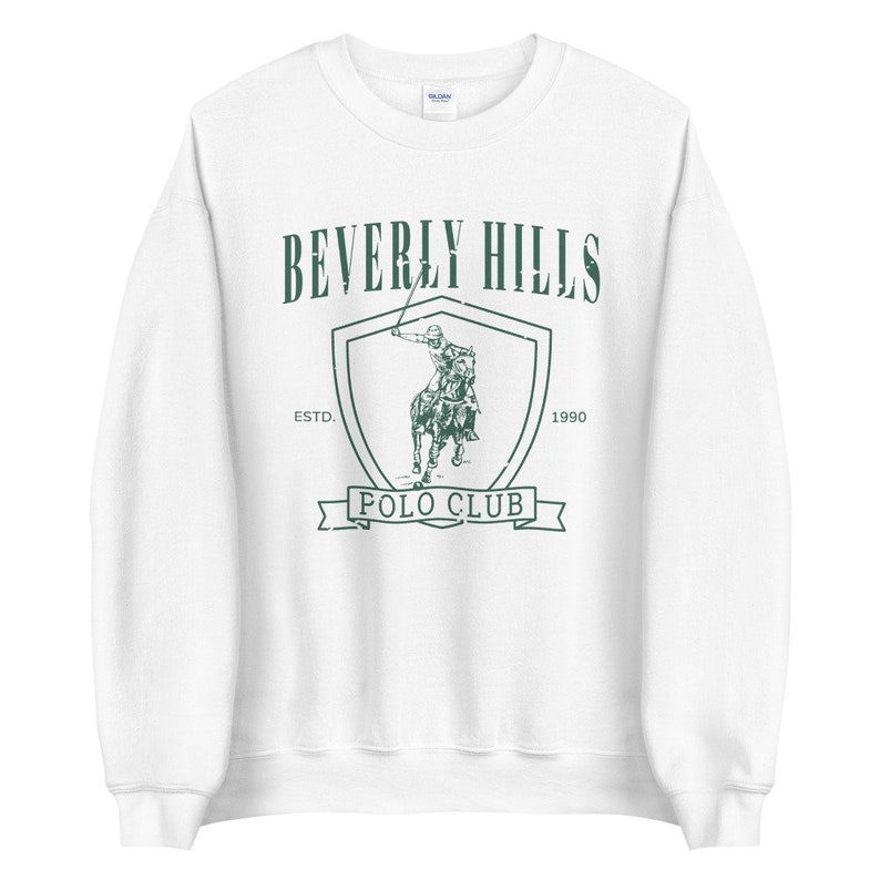 May include: White sweatshirt with a green graphic of a polo player on a horse, with the text "Beverly Hills Polo Club" and "Est. 1990".