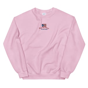 May include: Pink crewneck sweatshirt with a small embroidered Puerto Rican flag and the text "Puerto Rico, Isla del Encanto".