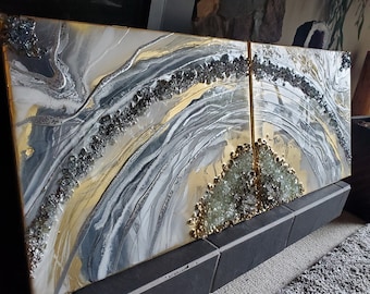 Könnte beinhalten: Zwei abstrakte Kunstleinwände mit einem Farbschema aus Gold, Weiß und Grau. Die Leinwände zeigen ein wirbelndes, fließendes Design mit einer kristallartigen Textur.