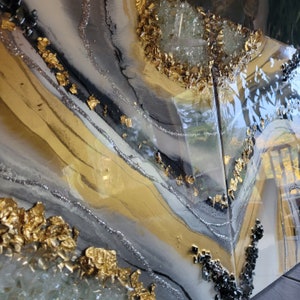 May include: Abstract art painting with gold leaf and glitter accents on a white and gray background.