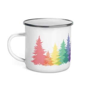 May include: White enamel mug with a rainbow design of pine trees. The trees are outlined in a rainbow pattern, with the colors fading from pink to purple.