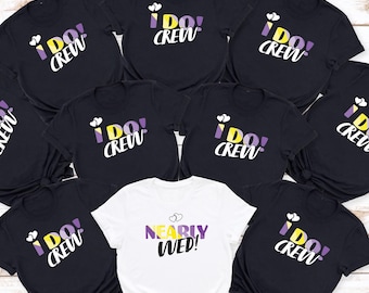 Könnte beinhalten: Ein Set aus acht schwarzen T-Shirts mit dem Text "I Do! Crew" in Weiß und einem gelben und violetten Herzdesign. Ein weißes T-Shirt hat den Text "Nearly Wed!" in Gelb und Lila.