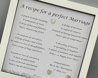 May include: A white framed picture with a poem about the ingredients for a perfect marriage. The poem is written in a decorative font and includes phrases like "a pinch of understanding", "a tablespoon of trust", and "a dollop of devotion". The picture also includes the text "Congratulations Mr & Mrs Harrington 5th May 2022".