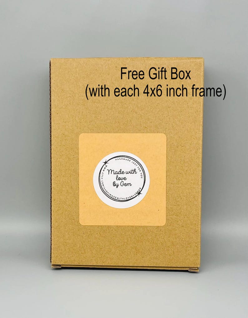 May include: A brown cardboard gift box with a sticker that reads "Made with love by Gem." The text "Free Gift Box (with each 4x6 inch frame)" is printed on the box. The box is on a gray background.
