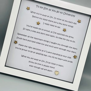 May include: A white frame with a poem inside. The poem is about a son going to university. The poem is written in black ink and there are gold stars and a heart on the white background.