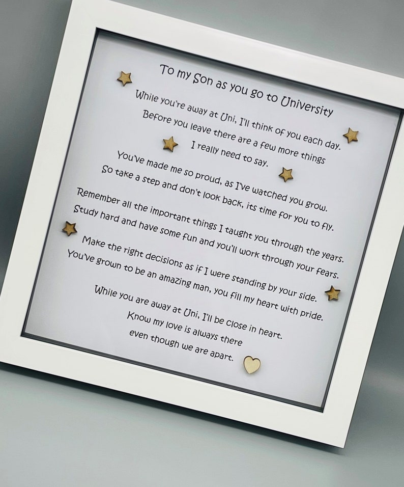 May include: A white frame with a poem inside. The poem is about a son going to university. The poem is written in black ink and there are gold stars and a heart on the white background.