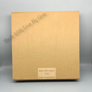 Peut inclure: Une bo&icirc;te en carton marron avec une &eacute;tiquette indiquant "Made with love by Gem" et une adresse de site web.