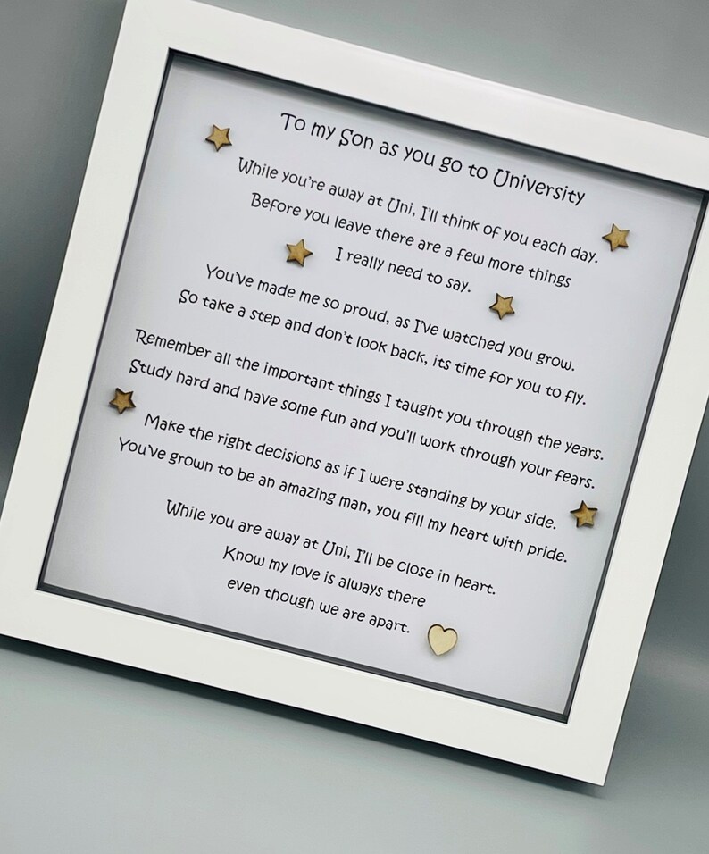 May include: A white frame with a poem inside. The poem is about a son going to university. The poem is written in black ink and there are gold stars and a heart on the white background.