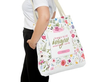 Sac de transport en tissu blanc, avec un imprimé floral et une inscription : I'm made by the cheaf designer...