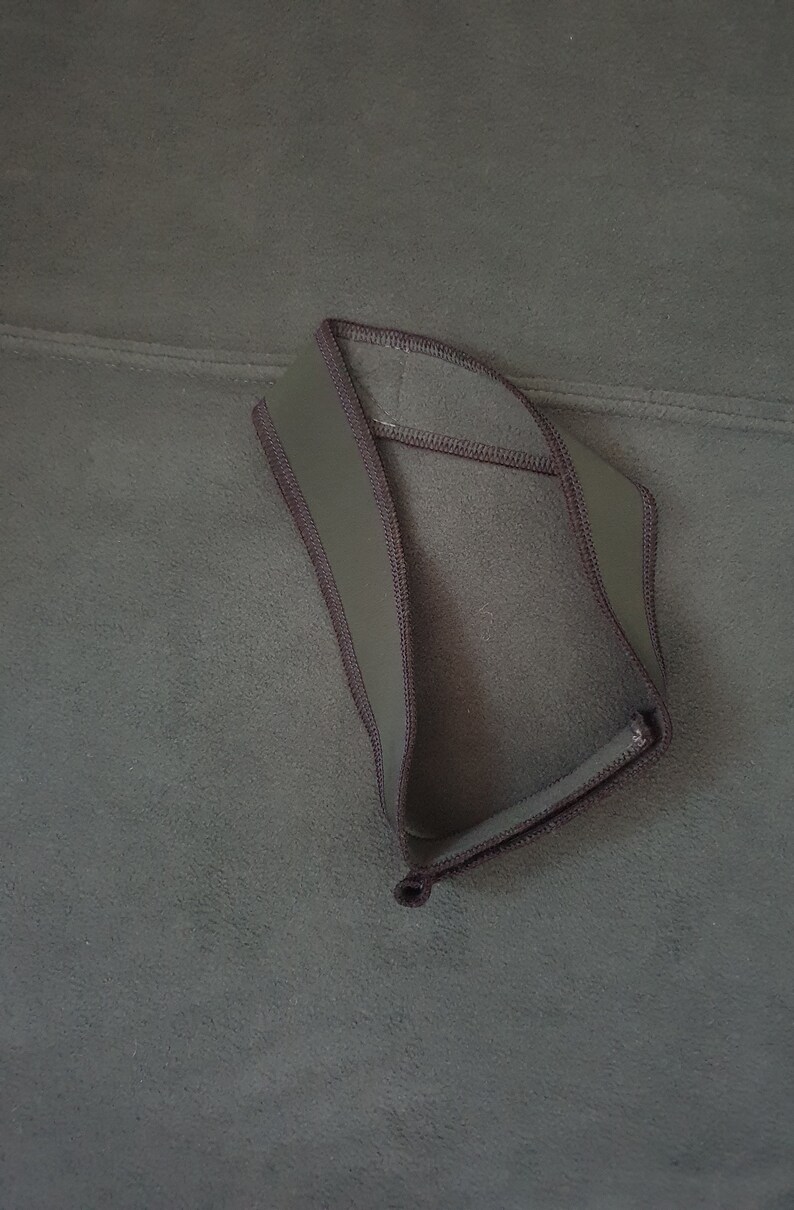 May include: A dark green fleece headband with a brown trim.