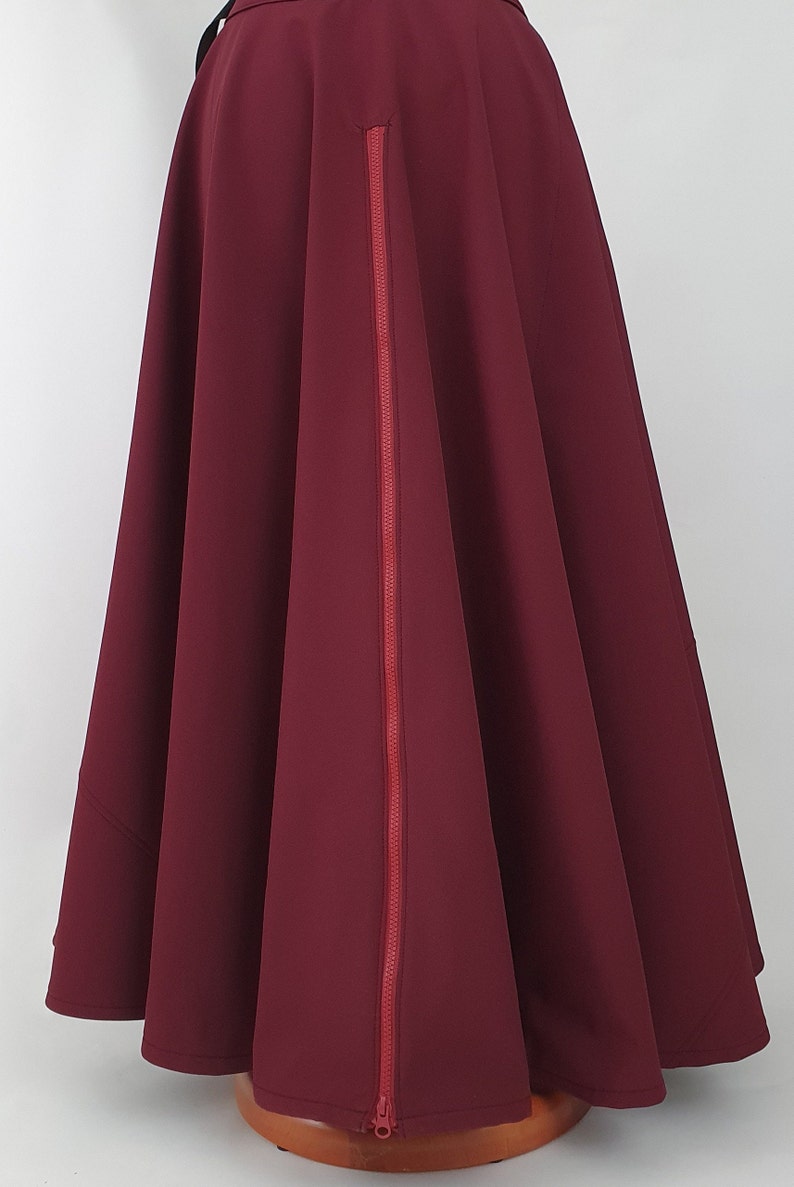 May include: A burgundy skirt with a red zipper down the back.