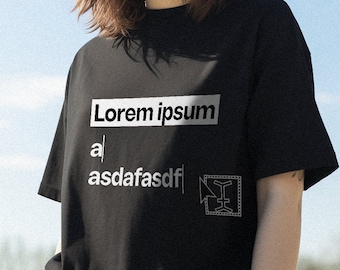 Könnte beinhalten: Ein schwarzes T-Shirt mit einem weißen Grafikdesign, auf dem "Lorem ipsum" und "asdafasdf" steht, sowie eine kleine Grafik eines Quadrats mit einem nach rechts zeigenden Pfeil.