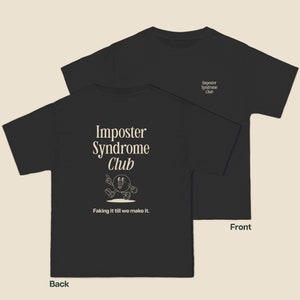 K&ouml;nnte beinhalten: Schwarzes T-Shirt mit einer wei&szlig;en Grafik eines Comic-Charakters und dem Text "Imposter Syndrome Club" und "Faking it till we make it."