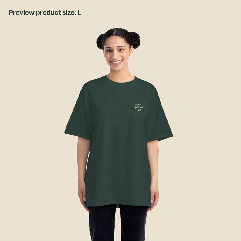 K&ouml;nnte beinhalten: Ein dunkelgr&uuml;nes T-Shirt mit dem Aufdruck "Imposter Syndrome Club" auf der Vorderseite.
