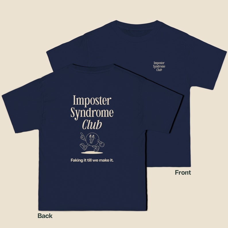 K&ouml;nnte beinhalten: Ein marineblaues T-Shirt mit dem Text "Imposter Syndrome Club" und einer Comicfigur auf der R&uuml;ckseite. Die Vorderseite des Shirts tr&auml;gt den Text "Imposter Syndrome Club" in einer kleineren Schriftart.